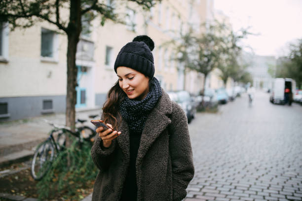 молодая женщина ходить и текстовые сообщения в берлине prenzlauer берг - berlin kreuzberg фотографии стоковые фото и изображения
