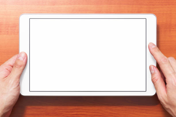 istock Closeup of hands touching white tablet computer on wood table background with shadow. 1161075743