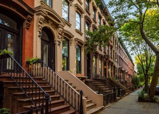 Photo of Scenic view of a classic Brooklyn brownstone block with a long facade and ornate stoop balustrades on a summer day in Clinton Hills, Brooklyn