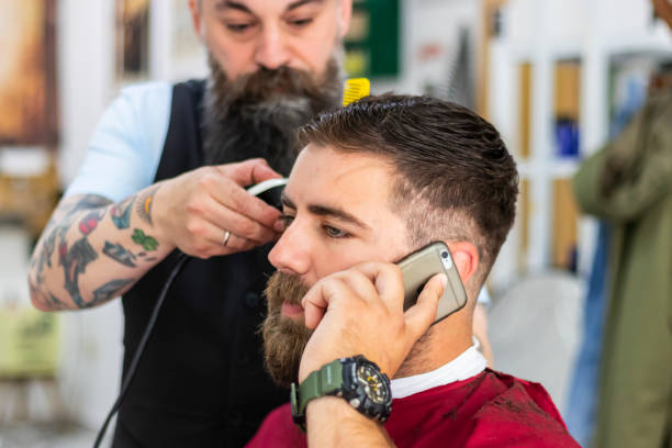 istock Young man speaking on mobile phone at barber's shop 1161088504