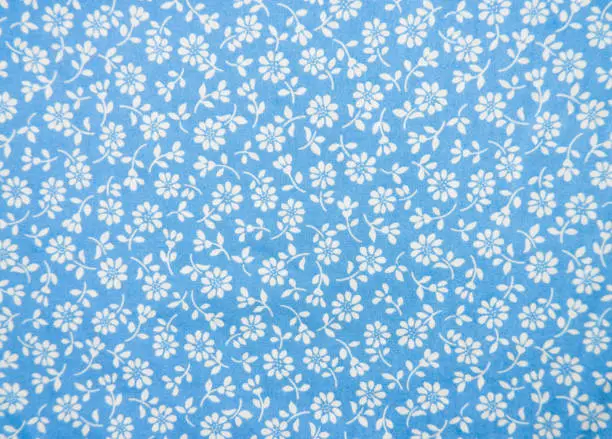 Photo of Fabric with Flower Pattern Useful for Texture. Beautiful Antique Vintage Blue Floral Fabrics Textured Background for an Empty Surface and Wallpaper. Closeup of Flowers on Blue Cloth for business.