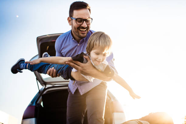Playful single father having fun with his small boy on the street.