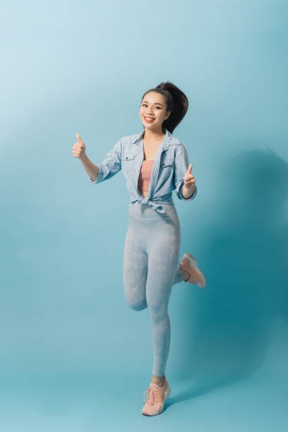 istock Charming excited crazy woman jumping up on light blue background 1161091076