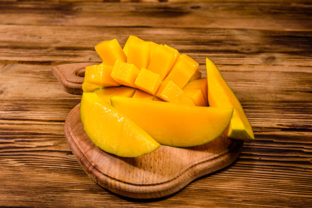istock Cutting board with chopped mango fruit on a wooden table 1161091918