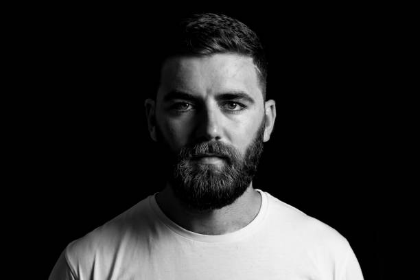 Low key portrait of young bearded man Low key portrait of young bearded man razor blade photos stock pictures, royalty-free photos & images