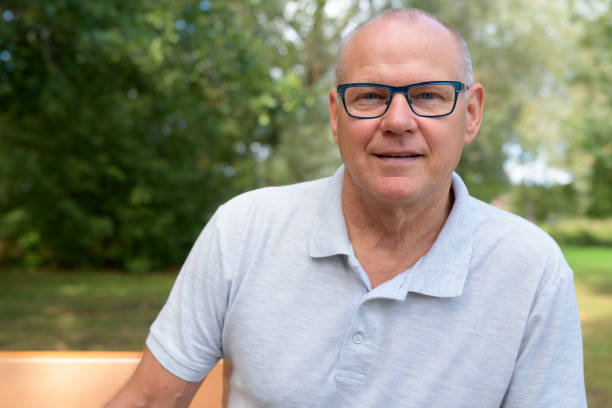 Face Of Handsome Senior Man Sitting At The Park Portrait of handsome senior man relaxing at the park northern european stock pictures, royalty-free photos & images