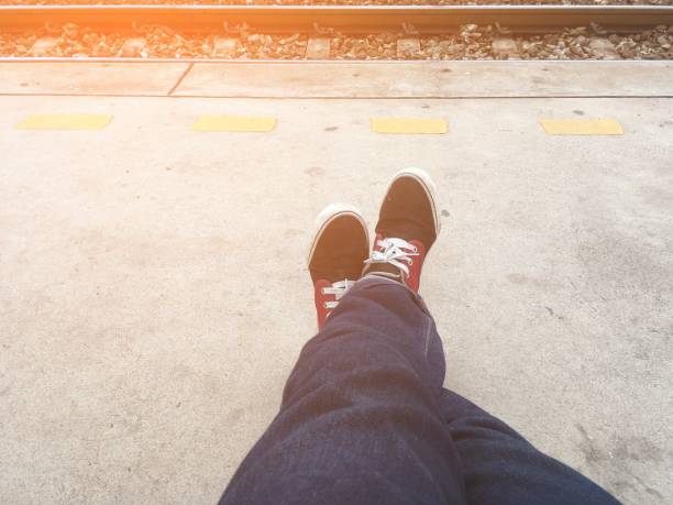 istock man leg sitting near railway at train station 1161109585