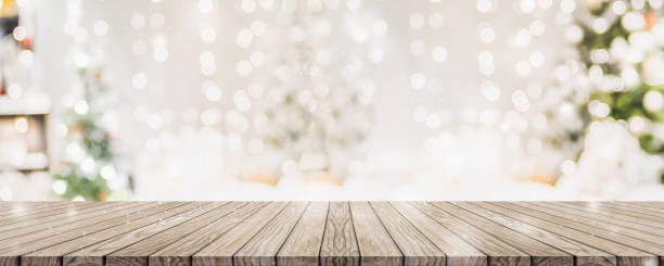 leere woooden tischplatte mit abstrakten warmen wohnzimmer dekor mit weihnachtsbaum string licht unschärfe hintergrund mit schnee, urlaub hintergrund, mock up banner für die anzeige von werbeprodukt. - vorhang fotos stock-fotos und bilder