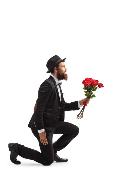 istock Bearded man kneeling and holding red roses 1161111622