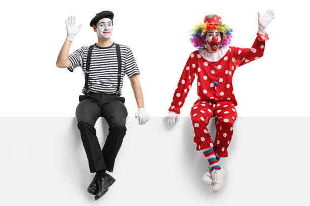istock Clown and a mime sitting on a panel and waving 1161111865