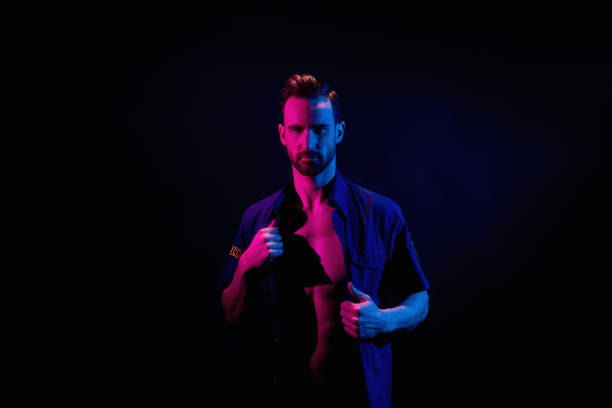 istock Handsome man on black background with red and blue lighting 1161114600
