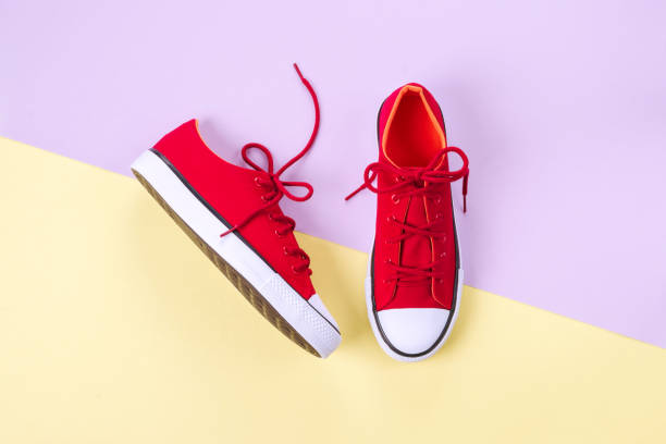 istock New red sneakers on yellow and violet background with copy space. 1161114700