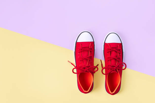 istock New red sneakers on yellow and violet background with copy space. 1161114702