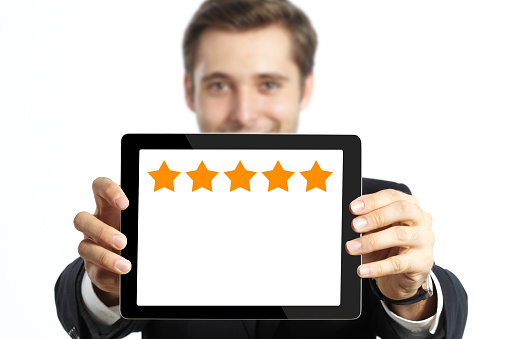 Businessman holding tablet pc with five stars on it.