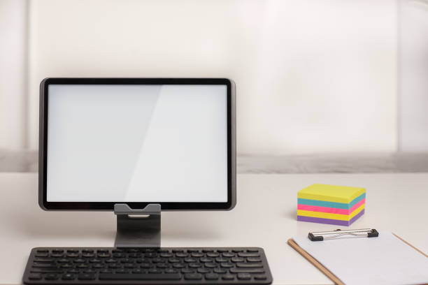 istock A tablet with a wireless keyboard, on a white desk with note taking office supplies. 1161117710