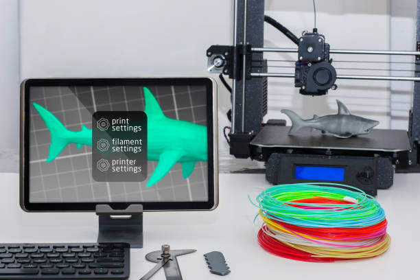 A wireless 3d printer setup using a tablet monitor, keyboard and 3d printing filament and machine. stock photo