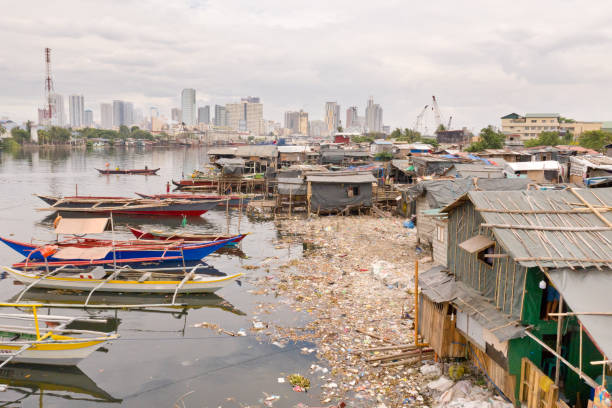 manila baraccopoli sullo sfondo di una grande città. case e barche dei poveri abitanti di manila - manila apartment poverty slum foto e immagini stock