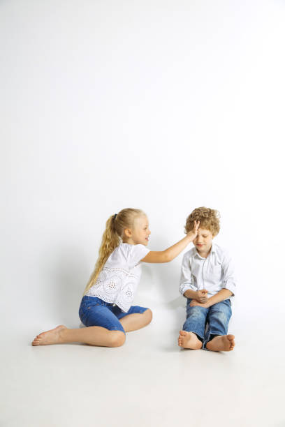 istock Boy and girl playing together on white studio background 1161121569