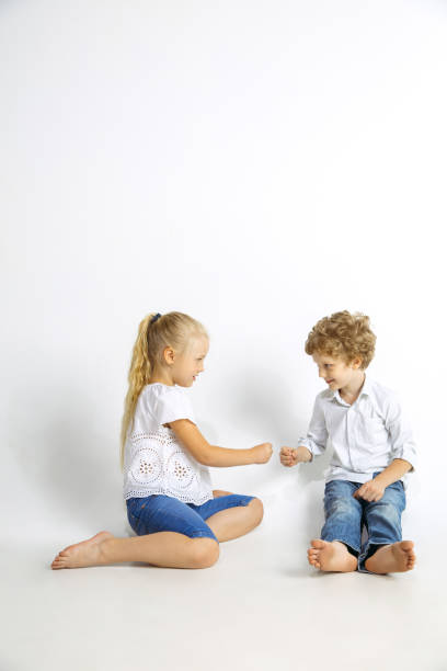 istock Boy and girl playing together on white studio background 1161121573