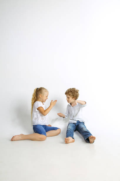 istock Boy and girl playing together on white studio background 1161121574