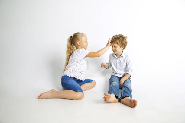 istock Boy and girl playing together on white studio background 1161121590