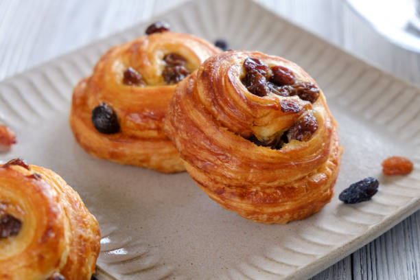 Delicious and crispy croissants with coffee on a white wooden table