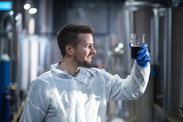 istock Technologist in brewery checking beer quality and transparency in distillery production line. 1161126778