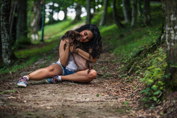 istock Young lady hugging her pet dog in park 1161128281
