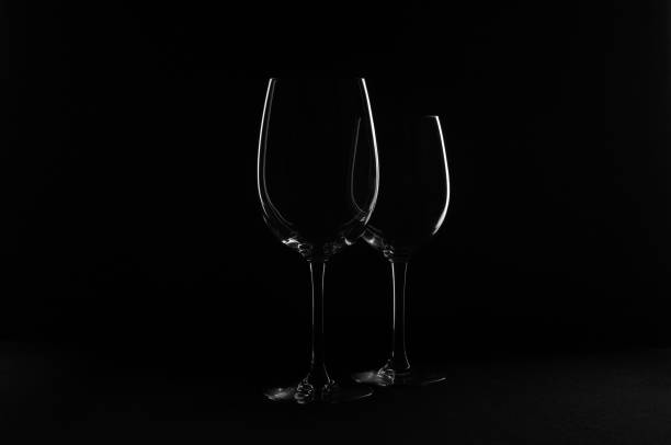 Still life of wine glasses and bottles, on a black background stock photo