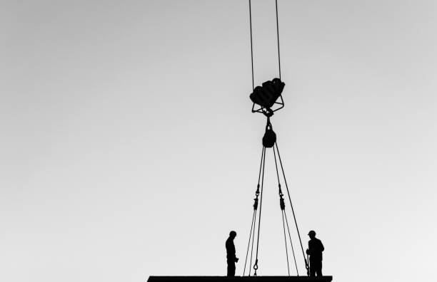 Aerial work platform is elevated over a group of multistory residential buildings in black and white.