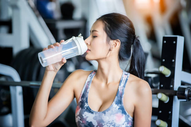 istock Young Woman Drinking Water From Bottle At Gym 1161136230