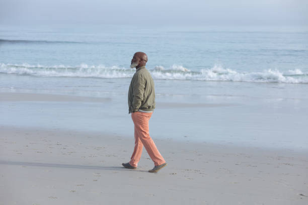 istock African-American man walking at the beach 1161137224