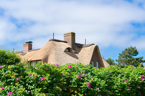 Kampen-Sylt, Germany, June 28 2019: Thatched Roof ( Reetdach ). Typical house with straw roof in small village on Sylt island in  Germany.
