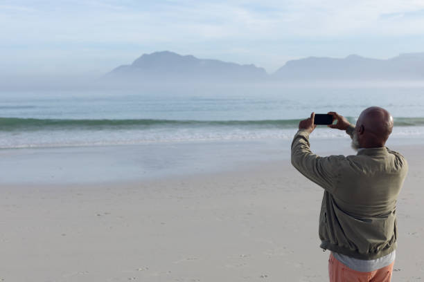 istock Man taking a picture at the beach 1161137987