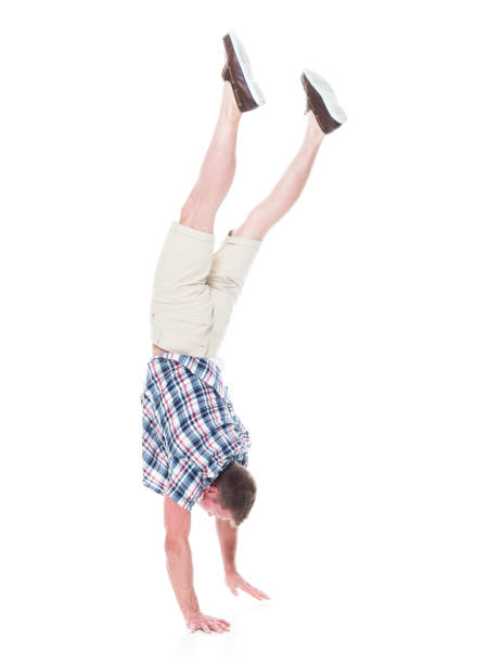 istock Handsome man in shirt and shorts is doing a handstand 1161138251