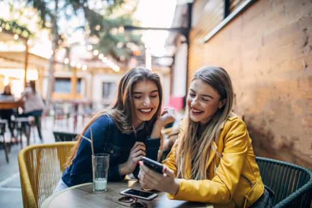 istock Two women sitting outdoors in cafe 1161144259