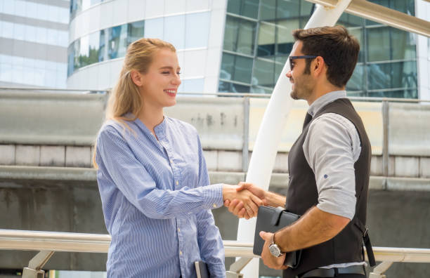 istock Business Colleagues Shaking Hands While Standing In City 1161147146