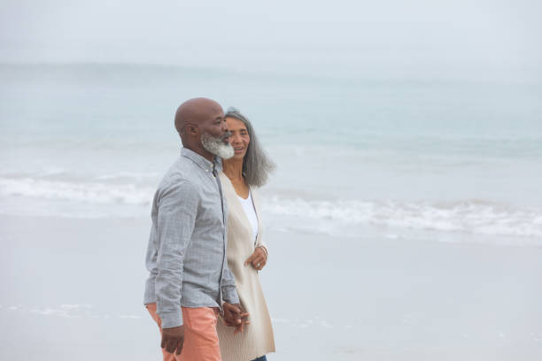 istock Couple holding hands while walking by the beach 1161147335