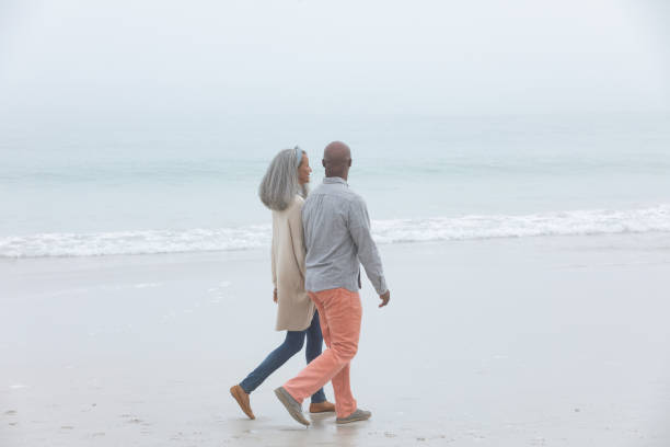 istock Couple holding hands while walking by the beach 1161147539