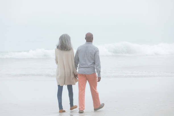 istock Couple holding hands while walking by the beach 1161147945