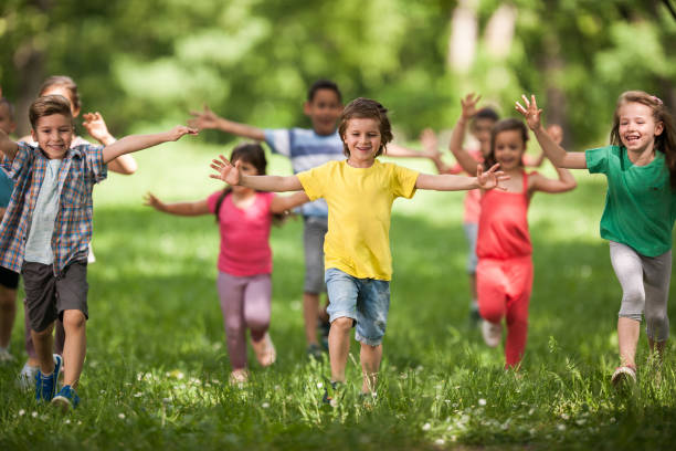 istock Large group of happy kids having fun while running in springtime. 1161148068