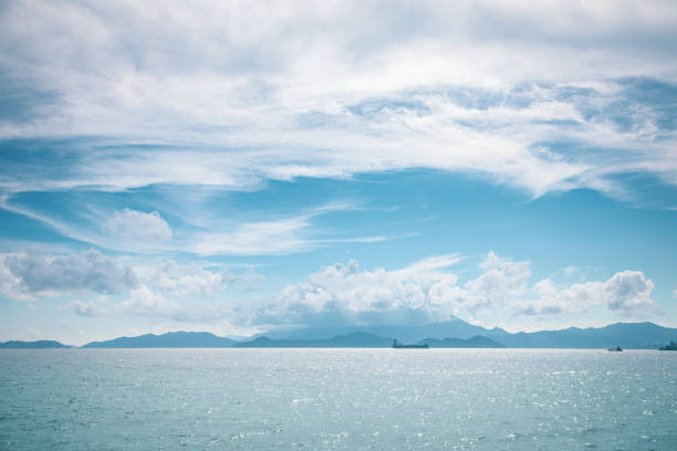 bateau de cargaison à l'horizon, ciel clair, projectile large - hong kong sea sky cloud photos et images de collection