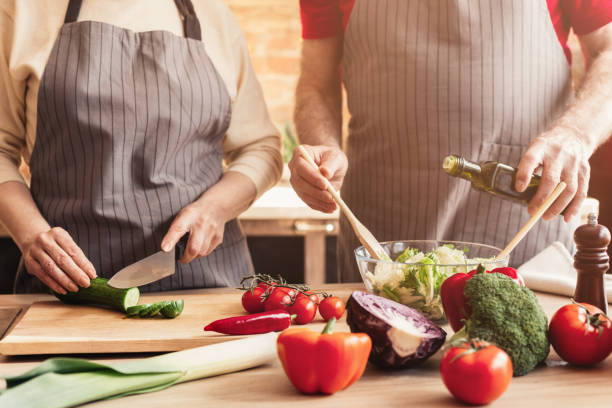 istock Mature couple preparing healthy vegetarian lunch at home kitchen 1161149637
