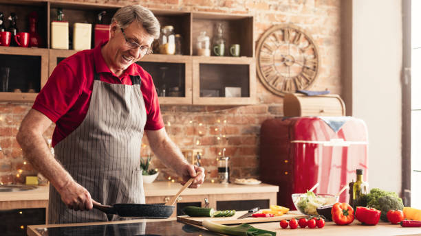 istock Cheerful senior man preparing lunch at kitchen 1161151001