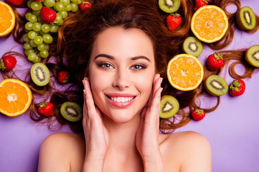 Close-up cropped portrait of nice attractive lovely well-groomed pure perfect, shine cheerful cheery feminine wavy-haired lady touching smooth clean clear skin isolated over violet purple background