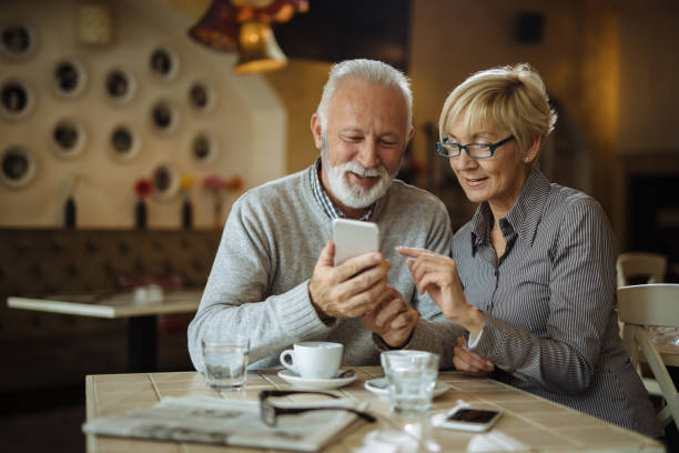 istock Senior couple using mobile phone in cafe 1161152915