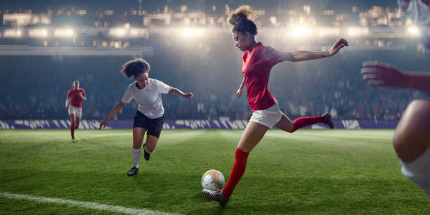 профессиональные женщины футболист о удар мяч во время матча - playing field effort outdoors human age стоковые фото и изображения