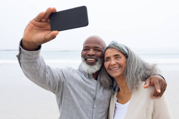 istock Couple taking a picture with smartphone at the beach 1161153035
