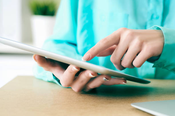 istock Close-up of female hands working with tablet computer. Woman using social network, texting and blogging. 1161153447