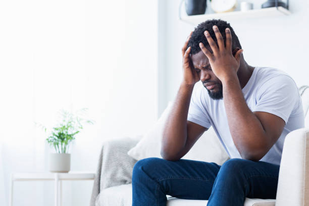istock African-american man suffering from headache at home 1161155094